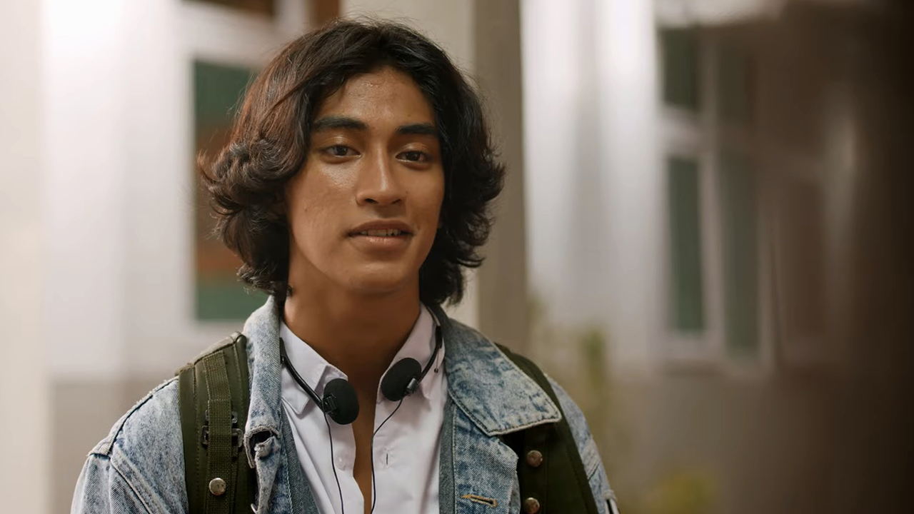 Tokoh Roy dalam film Balada Si Roy, mengenakan jaket jeans dan rambut gondrong.